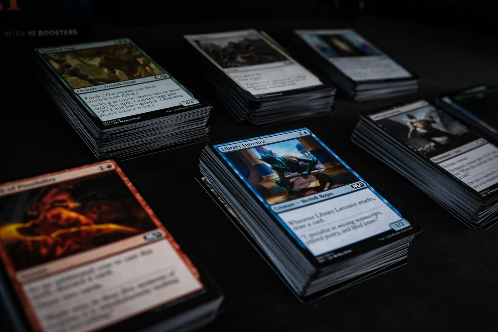 Magic: The Gathering cards sorted into colour-separated stacks on a dark table